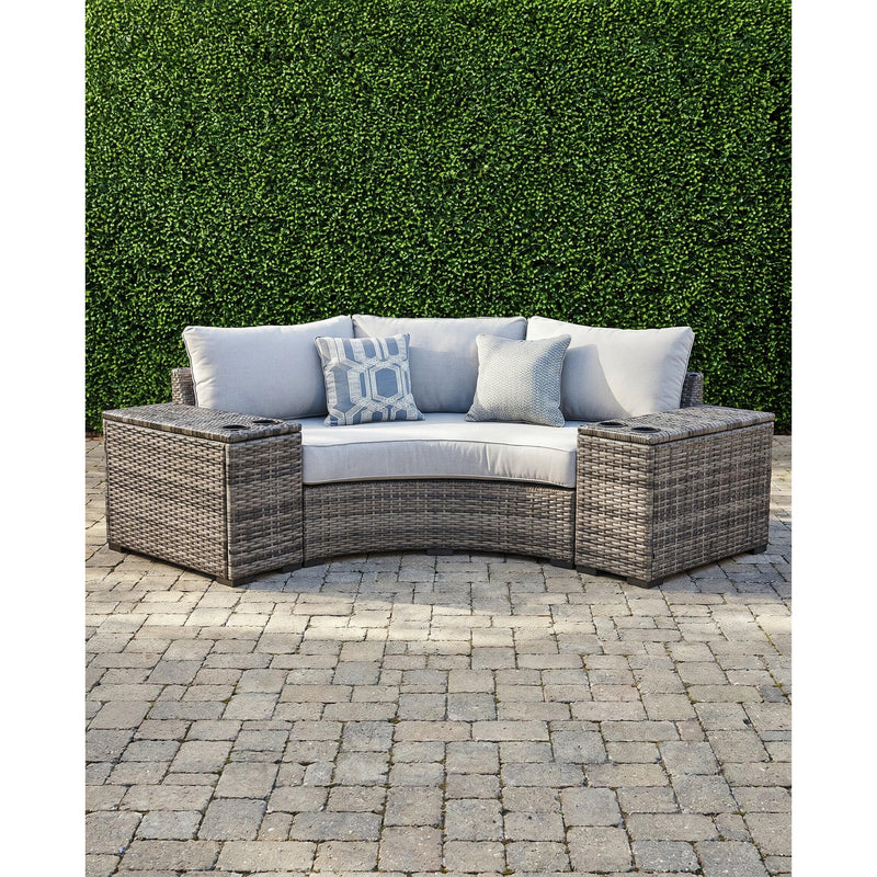 Montauk Curve outdoor 3-piece small space sectional — curved gray wicker loveseat with a drink-holder console on each side, on a paver patio