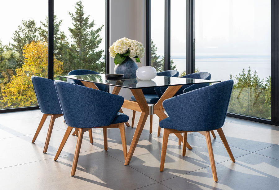 Navy upholstered custom dining chairs around a round glass-top table