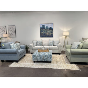 Locust Valley chair and a half shown in French blue and sage beside the dove grey sofa and printed cocktail ottoman — view 1