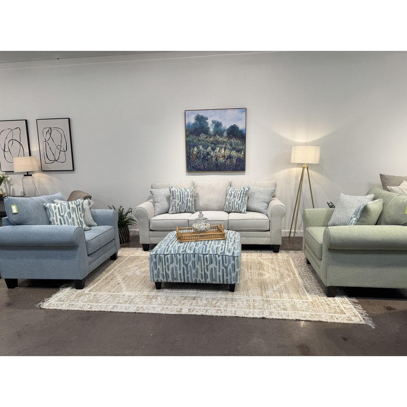 Locust Valley chair and a half shown in French blue and sage beside the dove grey sofa and printed cocktail ottoman