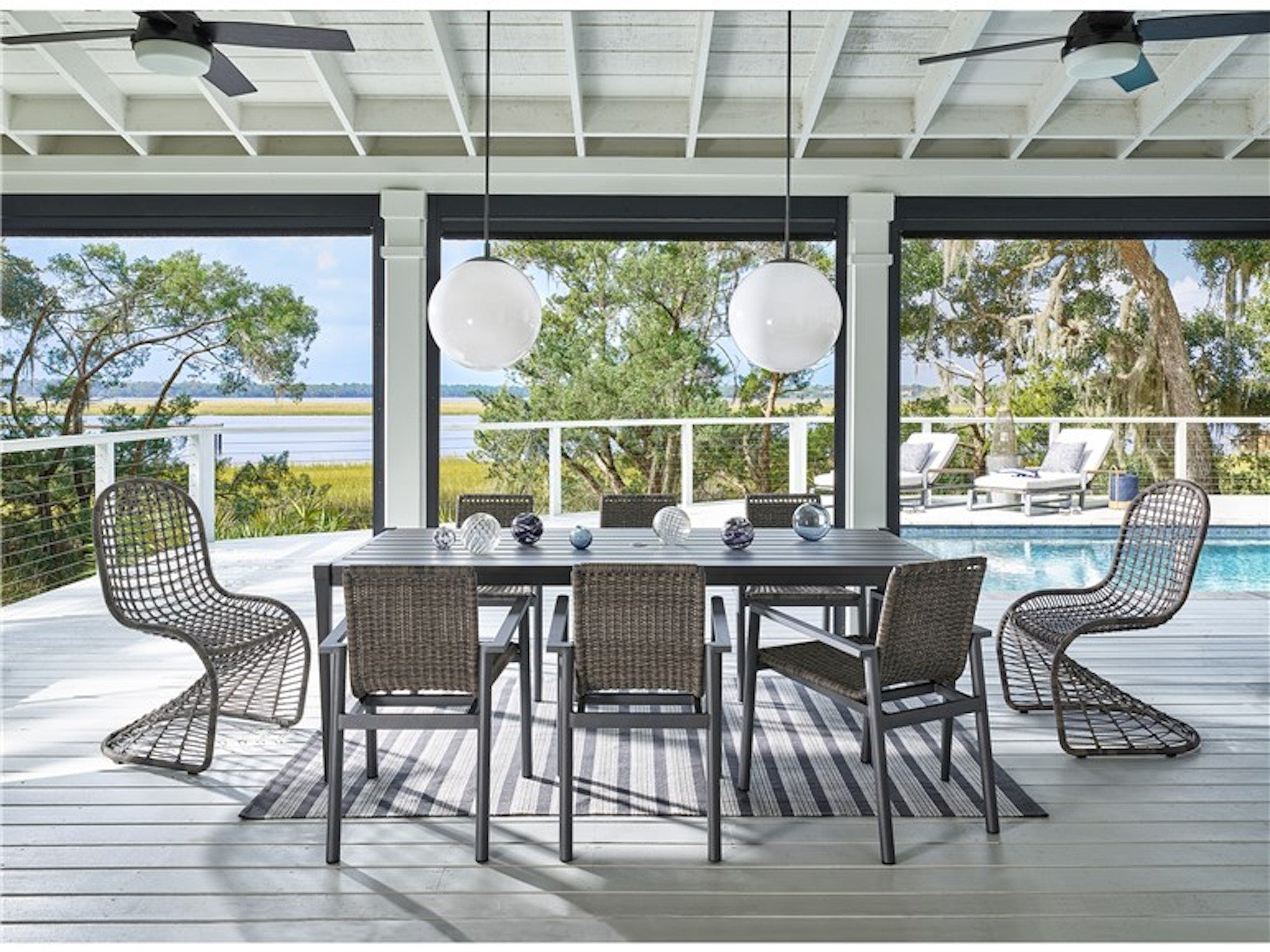 Panama Dining Chairs around a dining table on a pool-side deck with water views