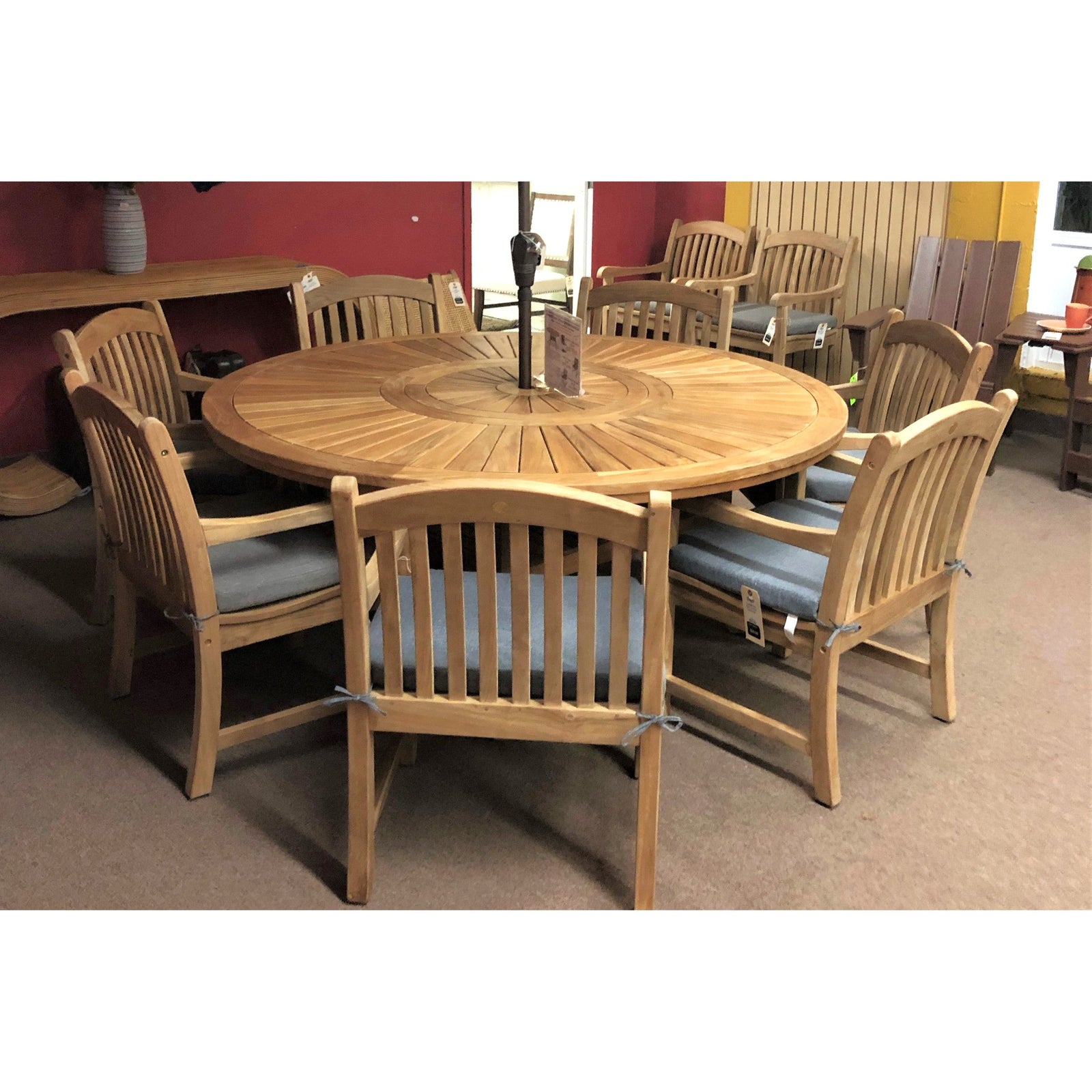 Komodo 70-inch round teak table with built-in lazy Susan and six Tista armchairs with gray cushions